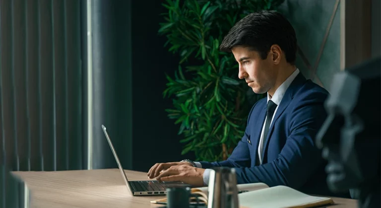 Business professional working on a laptop, illustrating what a registered agent actually does.
